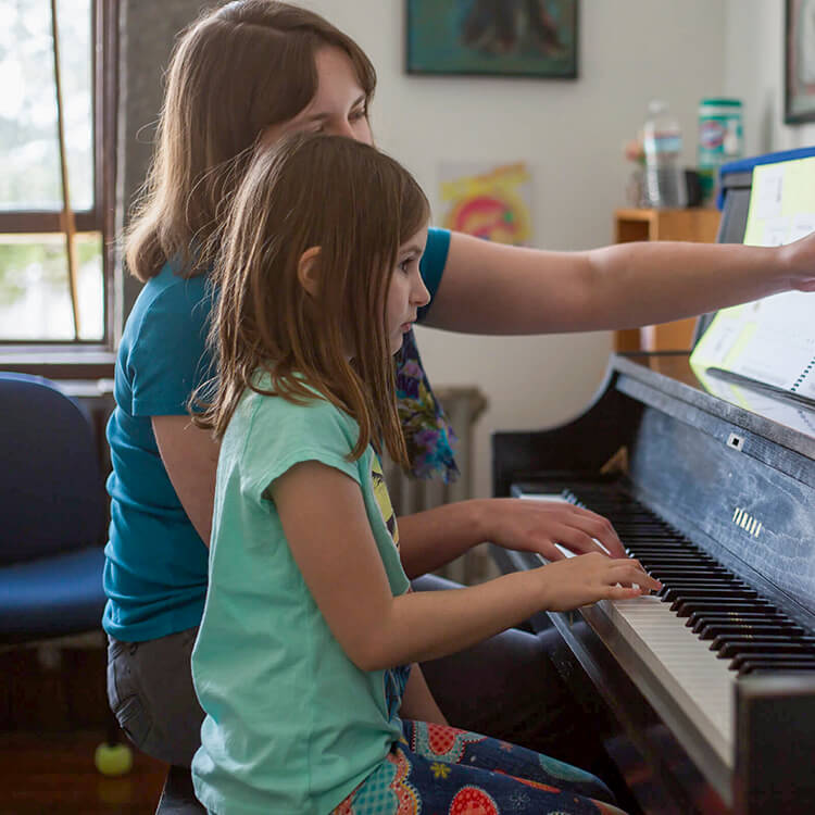 Photo of a teacher instructing a piano student